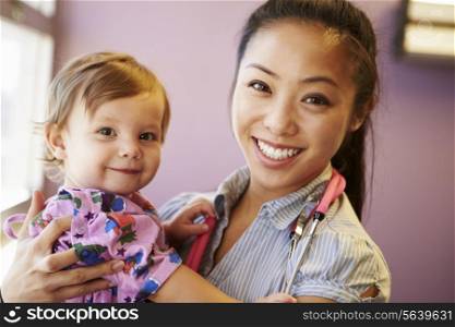 Young Girl Being Held By Female Pediatric Doctor