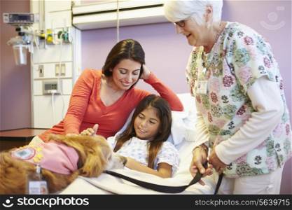 Young Girl Being Visited In Hospital By Therapy Dog