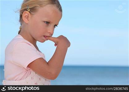 Young girl biting her thumbnail