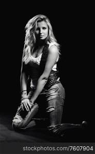 young, girl, blonde, jeans, clothes on a dark background kneels