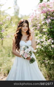 young girl bride in a white dress in a spring forest in lilac bushes on a wedding day