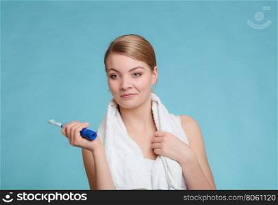 Young girl brushing oral cavity.. Pretty young girl with electric brush cleaning white teeth using toothpaste. Happy woman clean her oral cavity caring about dental health.