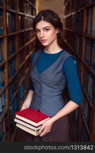 Young girl choose books for reading in college library. Knowledge acquisition concept.