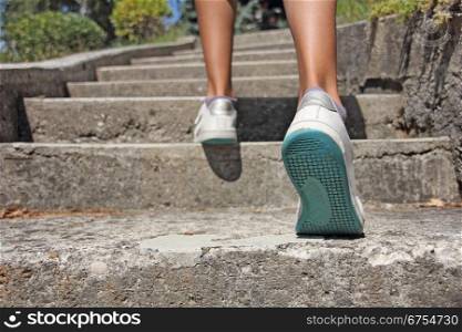 Young girl climbs on concrete stairs