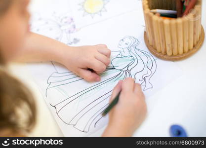 young girl coloring in coloring book. kids draws birthday party