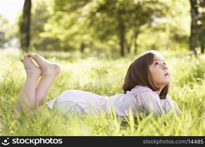 Young Girl Daydreaming Lying In Summer Field