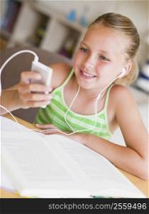Young Girl Distracted From Her Homework, Playing With An MP3 Player