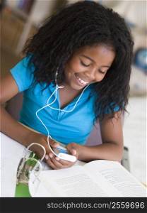 Young Girl Distracted From Her Homework, Playing With An MP3 Player