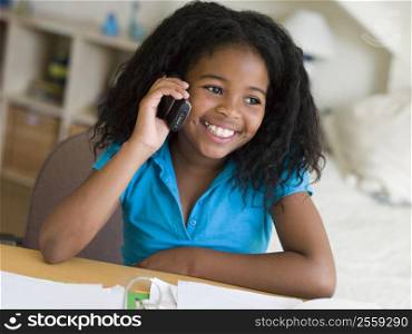 Young Girl Distracted From Her Homework, Talking On A Cellphone