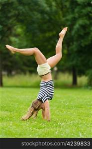 Young girl doing headstand at the park with narrow depth of field