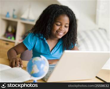 Young Girl Doing Her Homework On A Laptop