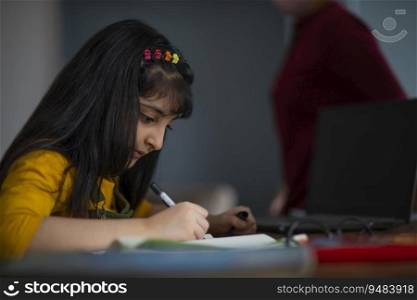 Young girl doing her school work at home 