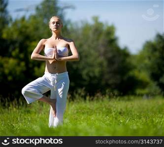 Young girl doing yoga in the park