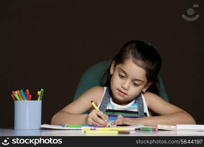 Young girl drawing over black background