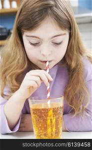 Young Girl Drinking Glass Of Soda Through Straw