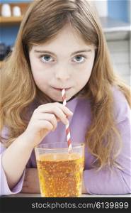 Young Girl Drinking Glass Of Soda Through Straw