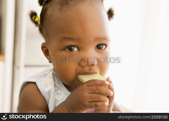 Young girl eating apple indoors