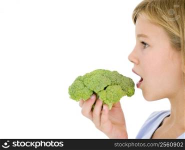 Young girl eating broccoli