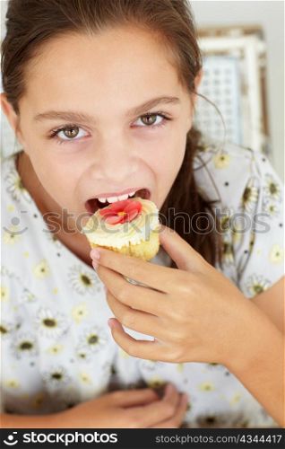 Young girl eating cupcake