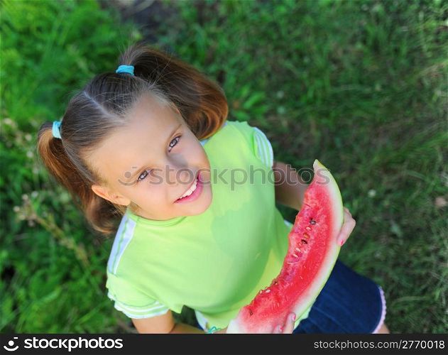 Young girl eating watermelon in the park