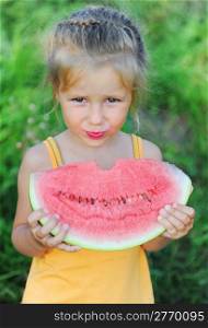 Young girl eating watermelon in the park