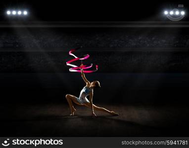 Young girl engaged art gymnastic at sports hall