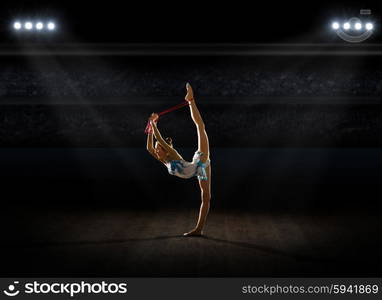 Young girl engaged art gymnastic at sports hall