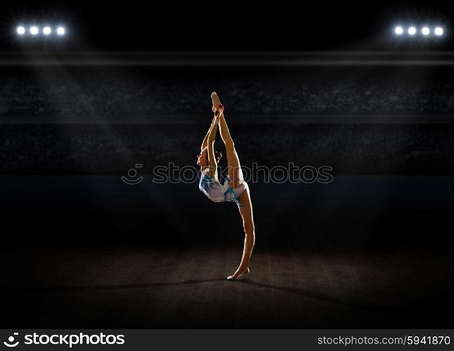 Young girl engaged art gymnastic at sports hall