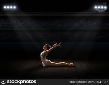 Young girl engaged art gymnastic at sports hall