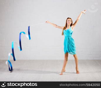 Young girl engaged art gymnastic on grey wall background