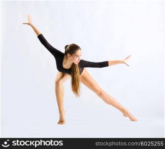 Young girl engaged gymnastic on grey