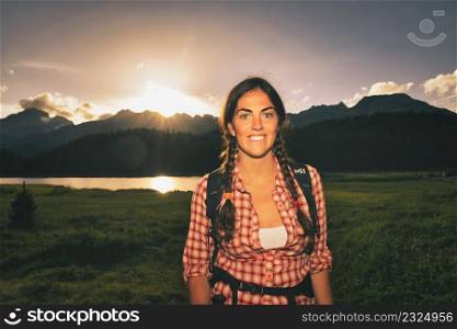 Young girl excursionist wing sunset in the mountains