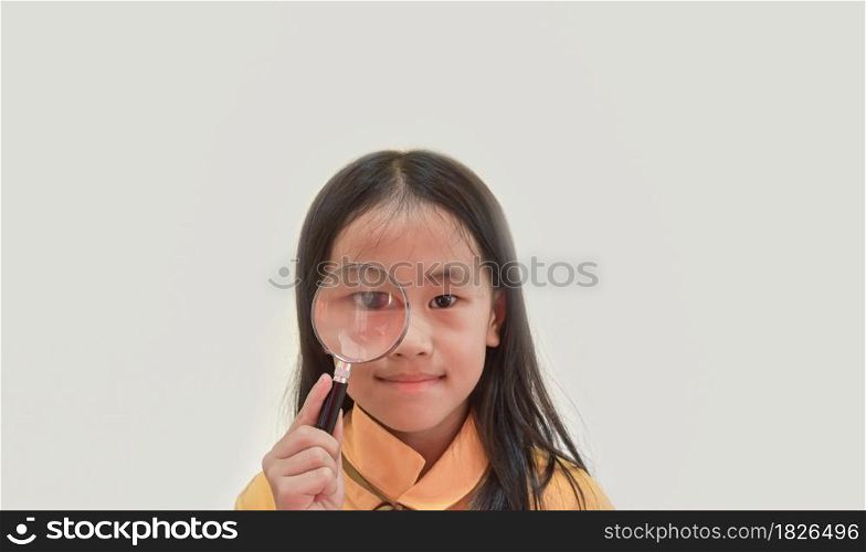 Young girl eye looking through a magnifying glass.