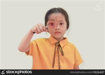 Young girl eye looking through a magnifying glass.