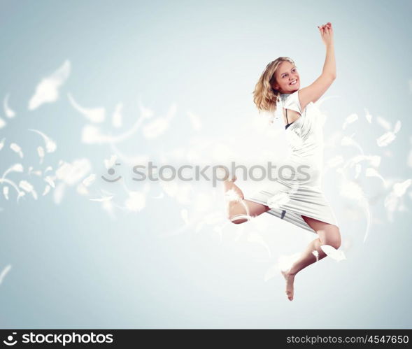 Young girl floating. Young girl flying among the feathers like a bird