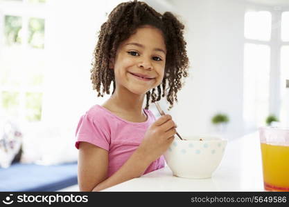 Young Girl Having Breakfast In Kitchen