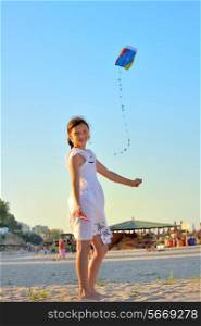 young girl having fun playing with kite beach summer