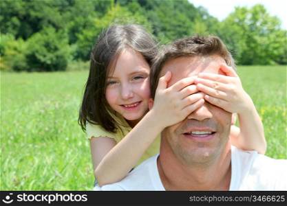 Young girl hiding her father&acute;s eyes