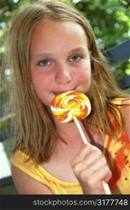 Young girl holding a big colorful lollipop candy