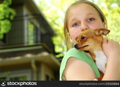 Young girl holding a chihuahua puppy outside