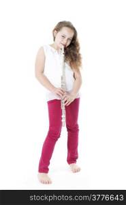 young girl holding flute standing on the floor of studio with white background