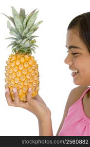 Young girl holding pineapple and smiling