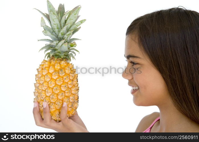 Young girl holding pineapple and smiling