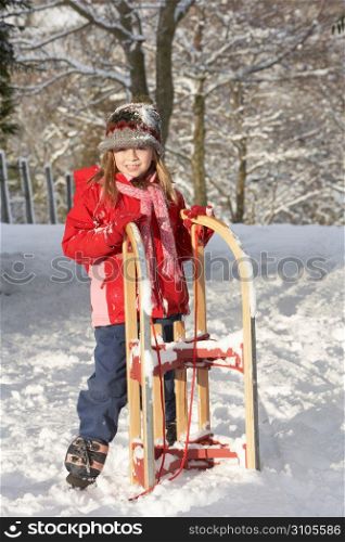 Young Girl Holding Sledge In Snowy Landscape