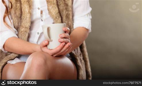 Young girl holding tea cup in hands. Woman having a break.