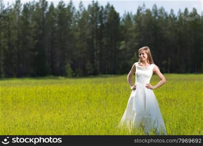 young girl in a wedding dress smiling in the field.