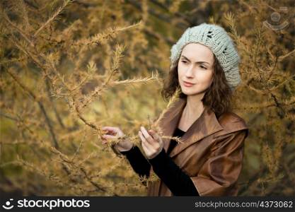 young girl in autumn forest standing near the tree. girl in autumn