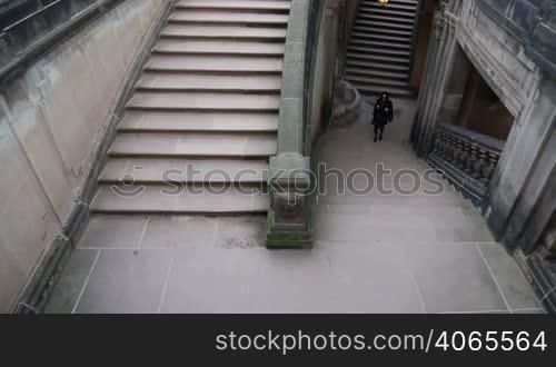 Young girl in black clothes escaping the dungeon on the stairs