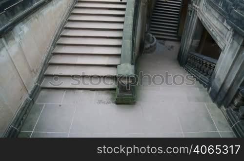 Young girl in black clothes going to dungeon on the stairs