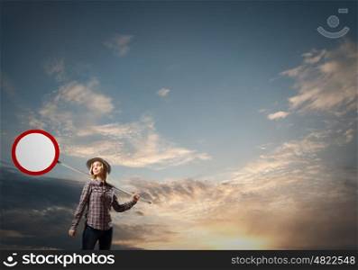Young girl in casual holding stop sign